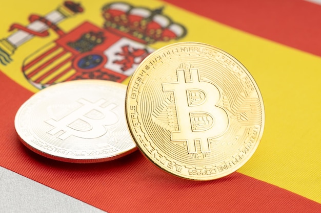 Monedas de criptomoneda Bitcoin en la bandera nacional de España. Concepto de regulación de la ley criptográfica