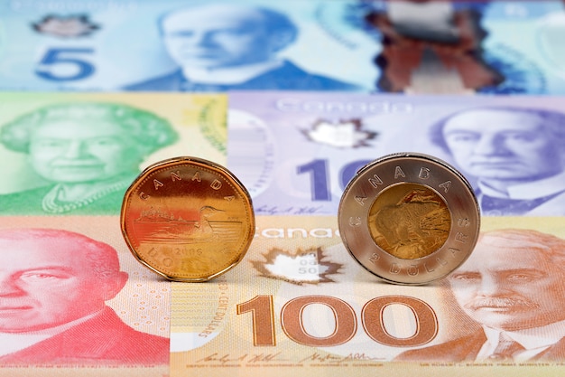 Monedas de dólar canadiense en billetes