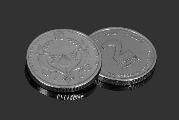 Monedas de dos Sheqalim sobre fondo oscuro Monedas y billetes