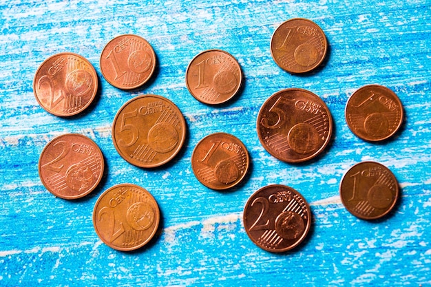 Foto monedas de euro de diferentes países sobre fondo azul uno, dos y cinco céntimos