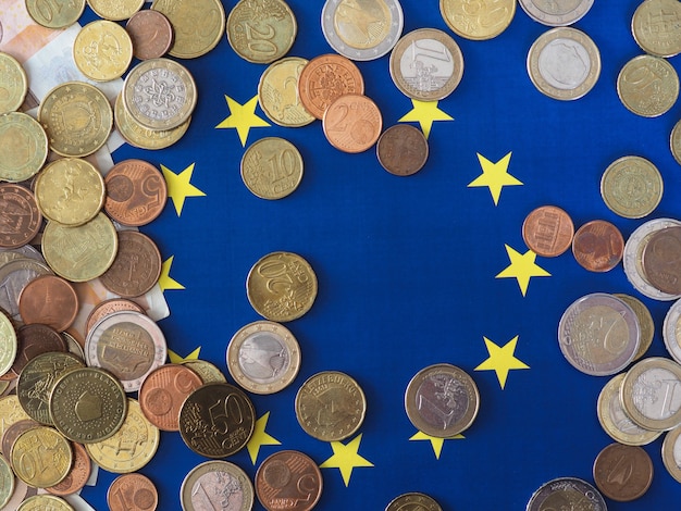 Foto monedas de euro (eur), moneda de la unión europea sobre la bandera de europa