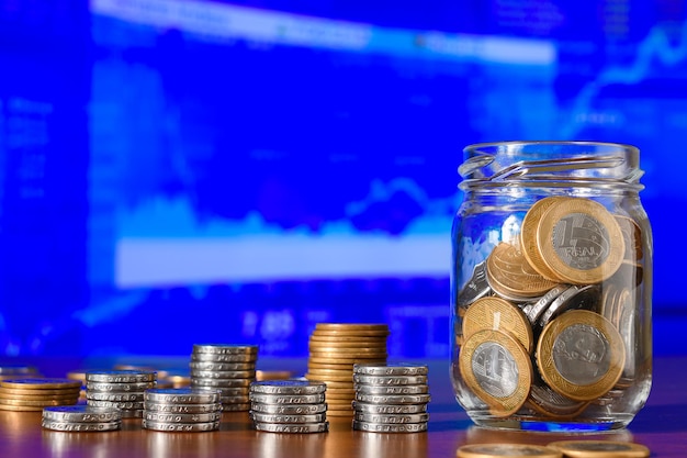 Monedas en un frasco de vidrio en el fondo de la bolsa de valores