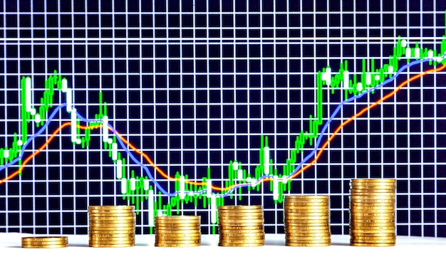 Las monedas de la hryvnia ucraniana se apilan en el contexto de un gráfico financiero