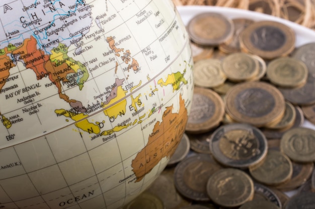 Monedas de lira turca al lado de un globo modelo