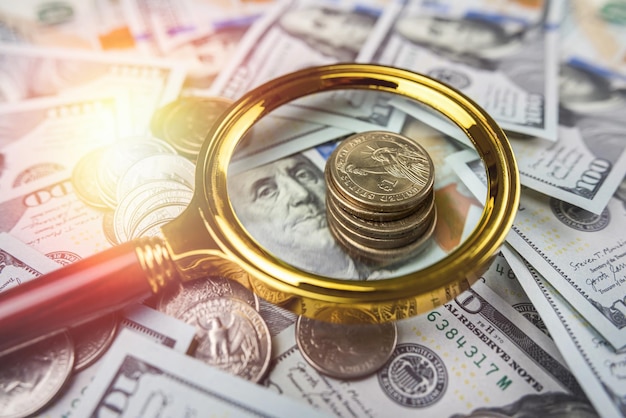 Monedas y lupa en dólar estadounidense