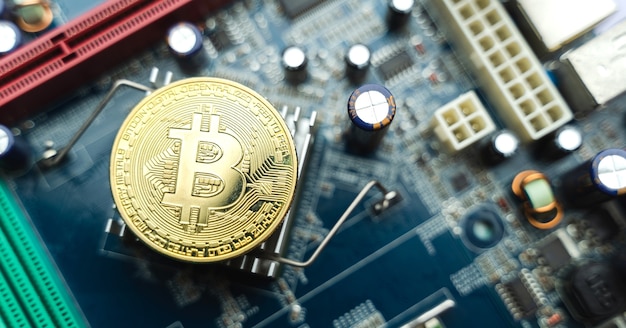 Monedas de oro Bitcoin en placa de circuito electrónico
