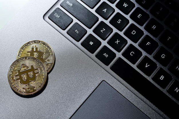 Las monedas de oro de Bitcoin en el teclado de la computadora portátil