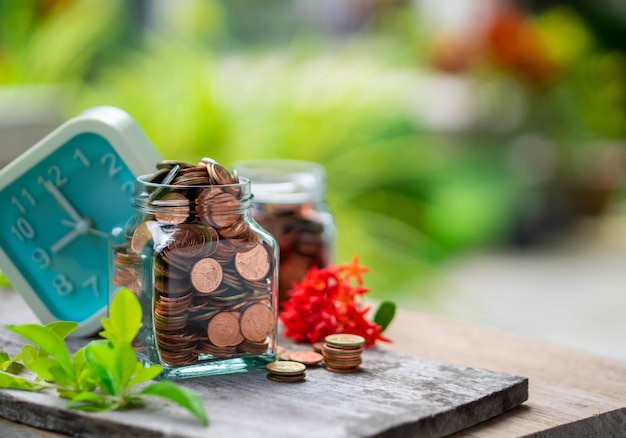 Monedas de oro en botella de vidrio y reloj