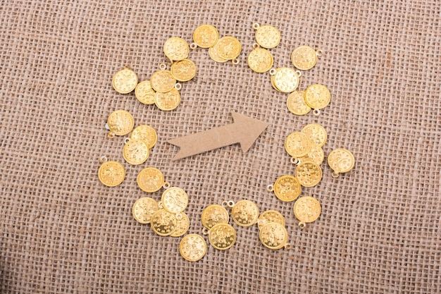 Monedas de oro falsas alrededor de la forma de flecha
