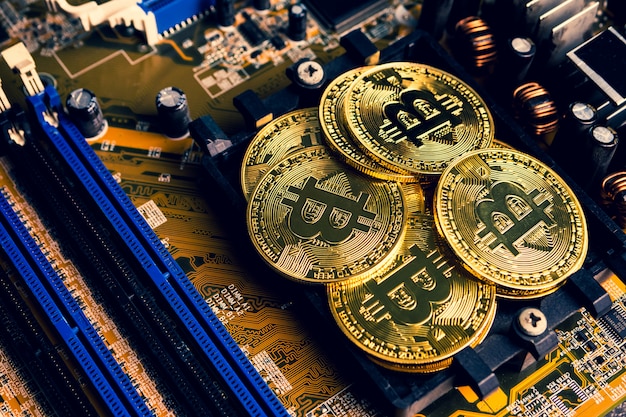 Monedas de oro con el símbolo de bitcoin en una placa base.