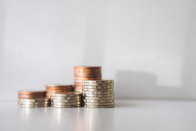 Monedas de la pila del primer con luz del sol usando como negocio y concepto financiero