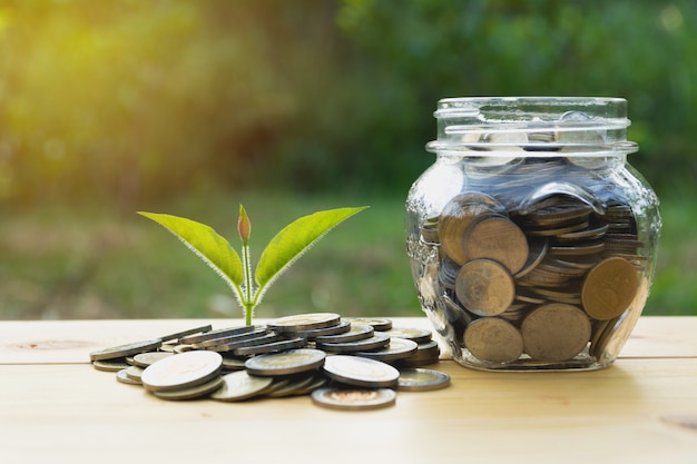 Monedas en el vaso con dinero pila paso crecimiento dinero