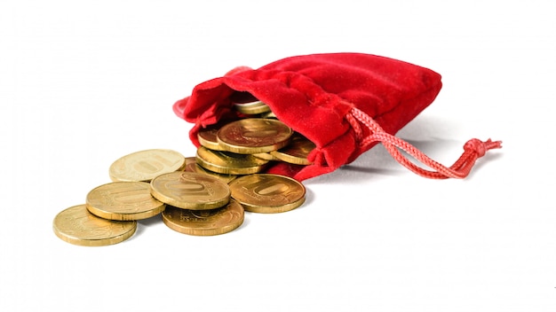 Las monedas se vierten de una bolsa roja aislada en un blanco.