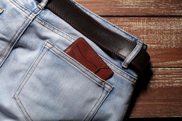 Monedero del bolsillo trasero de jeans sobre un fondo de madera