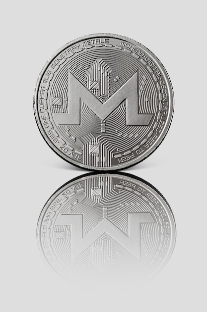 Monero de moeda de prata com reflexo na superfície branca brilhante. imagem conceitual para criptomoeda mundial e sistema de pagamento digital.