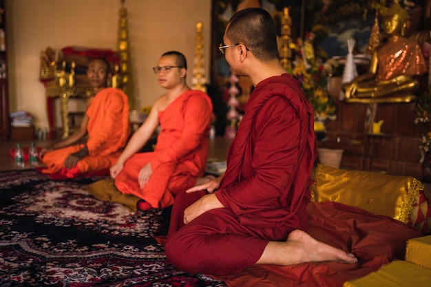 Monges budistas sentados dentro do templo
