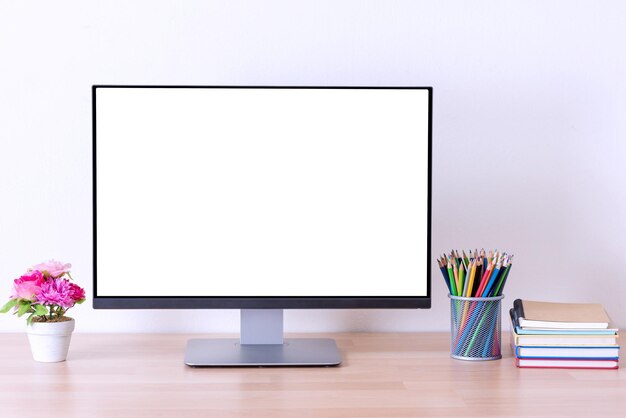 Monitor de computadora con suministros de oficina en el escritorio de la oficina