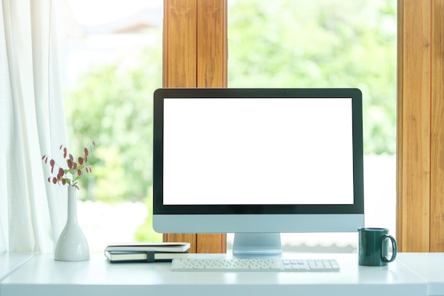 Foto monitor de computador de vista frontal com xícara de café de tela em branco e acessórios de escritório na mesa branca