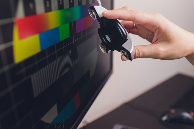 Monitor de fotógrafo com calibração de exibição no escritório, ferramentas para calibrar cores.