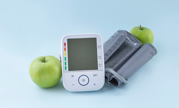 Monitor de pressão arterial e maçãs verdes frescas. Estilo de vida saudável e conceito de prevenção da hipertensão