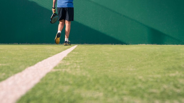 Monitor praticando esporte de remo na quadra ao ar livre homem ensinando aula de padel