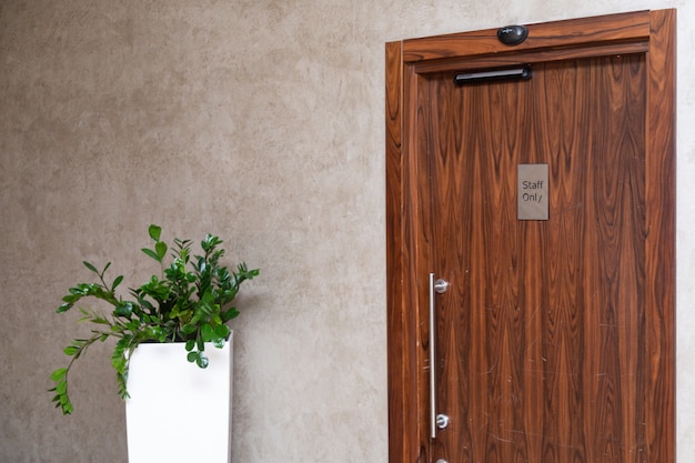 Monitoree al lado de la puerta de madera en una oficina elegante