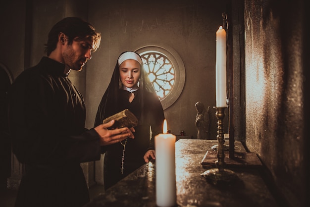 Monja y sacerdote rezando y pasando tiempo en el monasterio