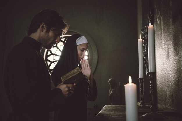 Monja y sacerdote rezando y pasando tiempo en el monasterio