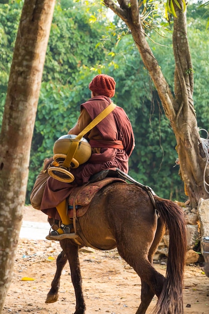 Monje budista montar a caballo en Chiangrai.