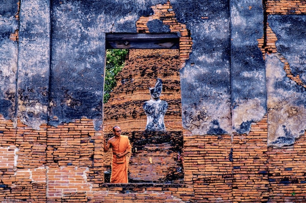 Monje budista de pie delante de la ruina del viejo Wat R