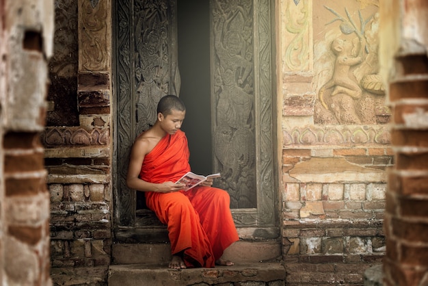 Monje leyendo el libro budista en el antiguo templo.