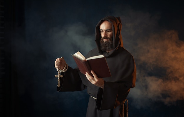 Monje medieval rezando con libro en la iglesia