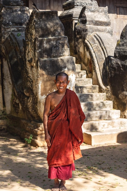 Un monje muy alegre se encuentra cerca de la pagoda. Mandalay. Birmania