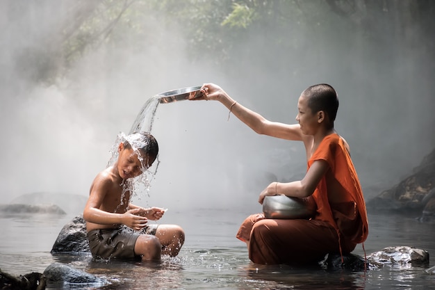 Monje y niño jugando agua