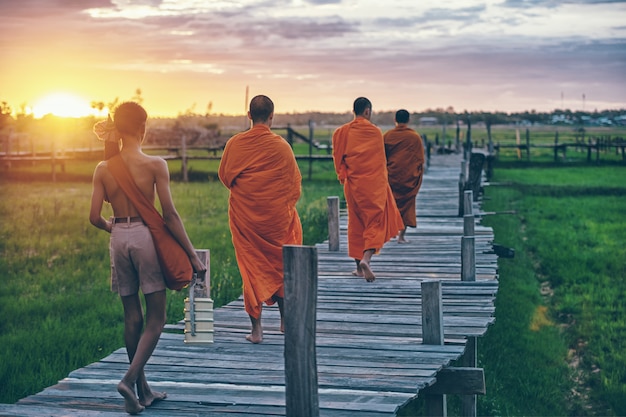 Monjes budistas en la mañana diaria limosnas tradicionales que dan en Tailandia.