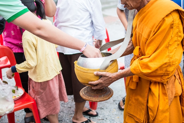 Los monjes budistas reciben ofrendas de comida de la gente para el fin del día de la Cuaresma budista