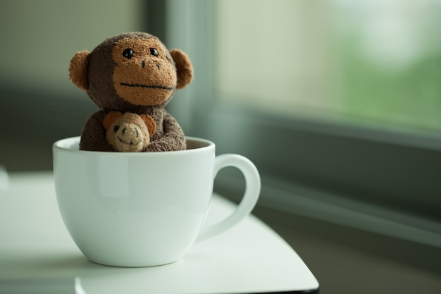 Monkey doll en una taza de café