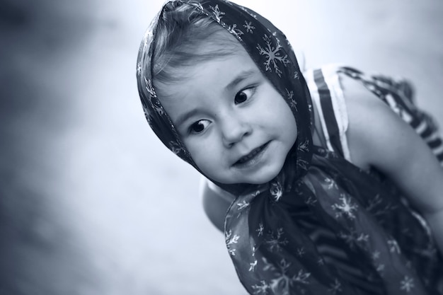 Monochromes Bild eines kleinen Mädchens in einem Kleid, das mit Taschentuch tanzt