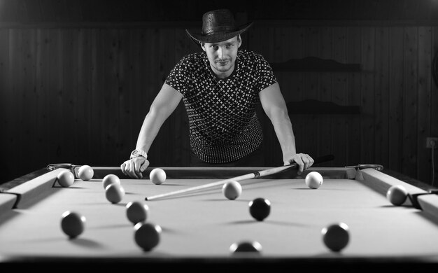 Monochromes Foto eines jungen Mannes, der Billard spielt