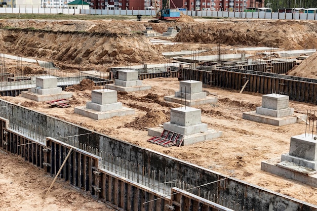 Monolithische Stahlbetonfundamente für den Bau eines großen Gebäudes Rostverk auf der Baustelle Baugrube mit Fundament Nahaufnahme