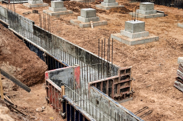 Monolithische Stahlbetonfundamente für den Bau eines großen Gebäudes Rostverk auf der Baustelle Baugrube mit Fundament Nahaufnahme