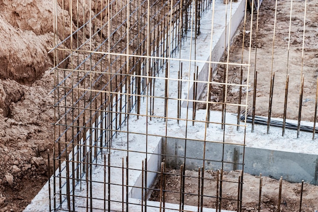 Monolithisches Fundament mit Metallverstärkung. Bildet vertikale Schalungskonstruktionen für den Keller eines Wohnhauses. Monolithisches Betonfundament. Stiftung unterstützen. Hausbau.