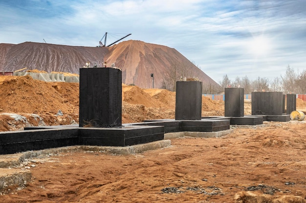 Monolithisches Stahlbetonfundament mit bituminösem Mastix abgedichtet Rostverk auf der Baustelle Baugrube mit Fundament Moderne Bautechnologien