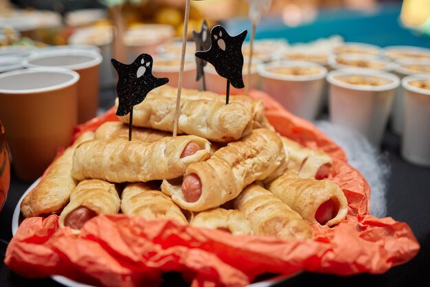 Monstros engraçados de sobremesa Heloween feitos de biscoitos com chocolate e marshmelow em cima da mesa