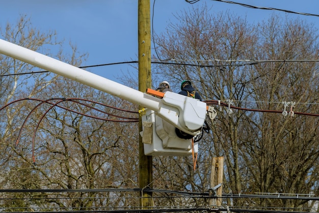 Montage und Installation von neuen Stützen und Drähten eines Stromleitungselektrikers, der Kabel an Strommasten repariert