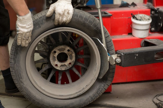 Montagem de pneu de carro em mudança mecânica. Reparação de pneus de rodas.