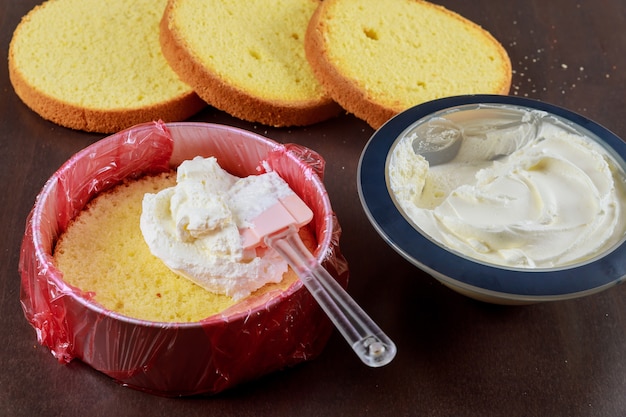 Montaje de tartas. pastel de capas con glaseado blanco.