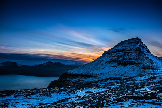 Una montaña con un atardecer de fondo