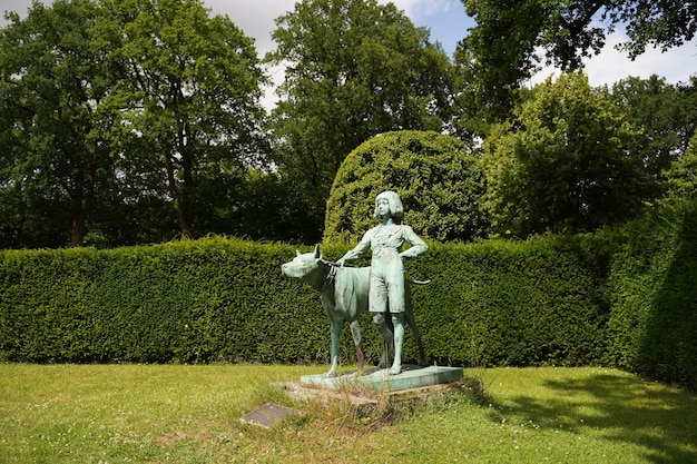 Montana Bay USA 12. August 2022 Statue eines unbekannten Mädchens mit einem riesigen Hund Hund in einem malerischen grünen Garten Denkmal für den unbekannten Bildhauer Gartendekoration