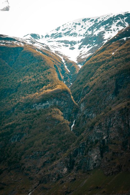 Foto una montaña con una cascada en el medio.